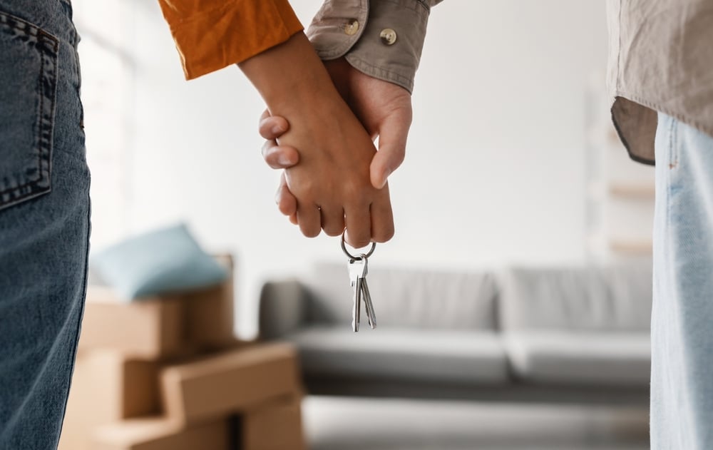Couple holding hands and a set of house keys
